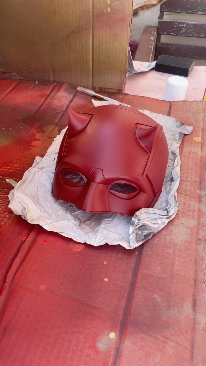 Red Daredevil helmet on the workbench during painting