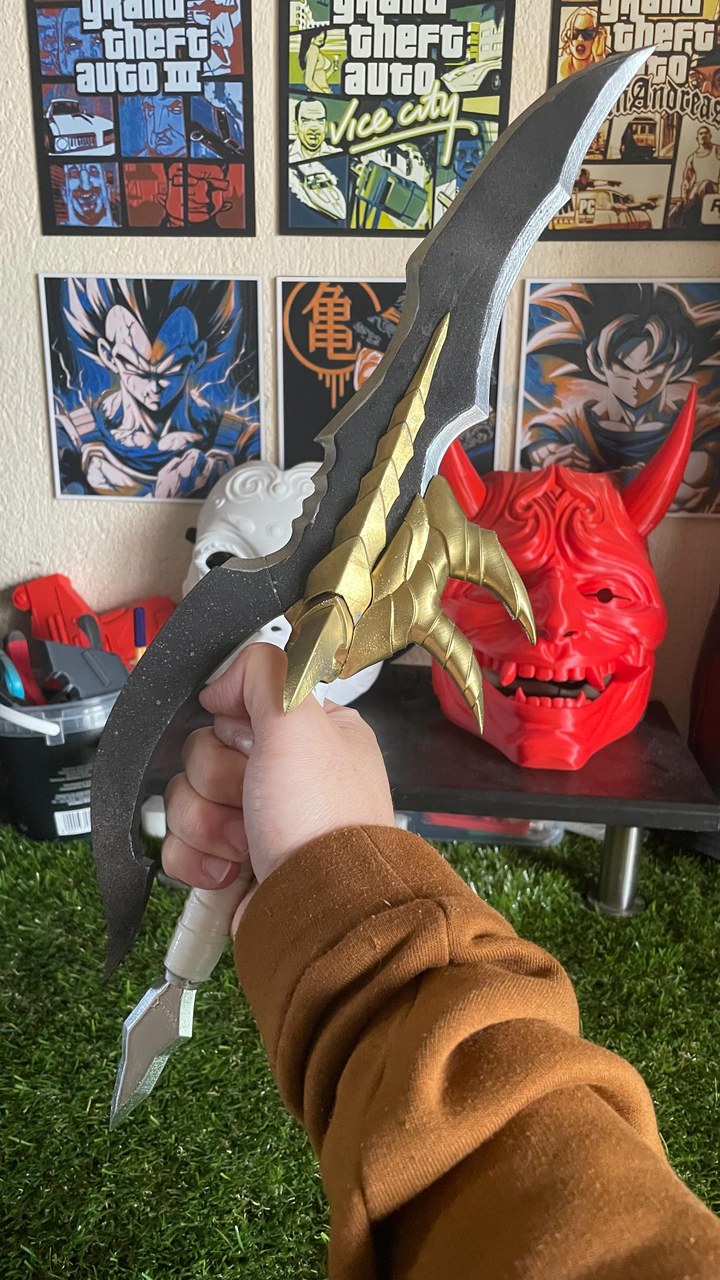 A finished Venom Fang cosplay prop with black, gold and silver paint and a wrapped white handle
